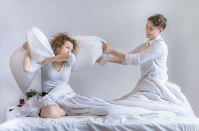 Young woman sitting on bed at home