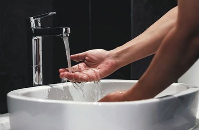 Cropped image of woman washing hands in home