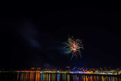 Firework display over river at night