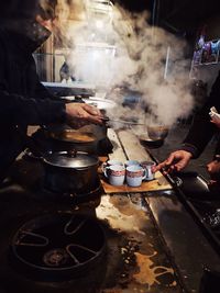 People working on barbecue grill in kitchen