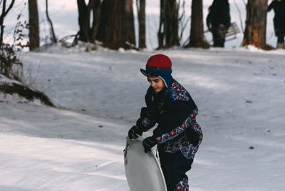 Boy with sledge walking on snow