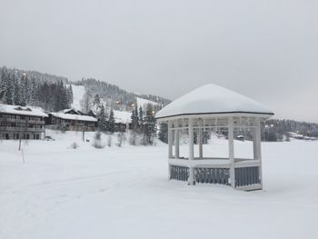 Snow covered built structure against clear sky