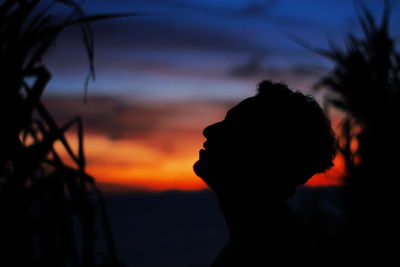 Close-up of silhouette man against orange sky