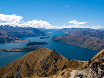 Scenic view of lake and mountains against blue sky in new zealand