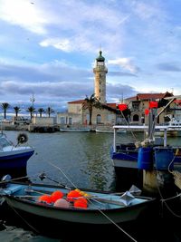 Boats moored at harbor against sky