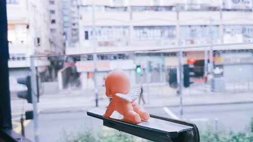 Close-up of angel figurine on window in city