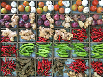 Assorted spices at market stall in manila. tomatoes, onions, green and red peppers, tamarind, ginger
