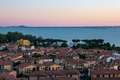 High angle view of townscape by bolsena lake against sky during sunset