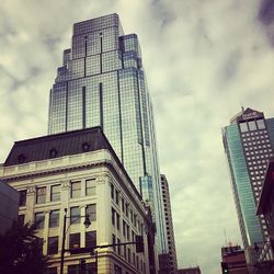 Low angle view of modern building against cloudy sky