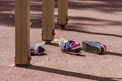 Two pairs of childrens' sneakers lies on the playground