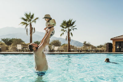 People in swimming pool against sky