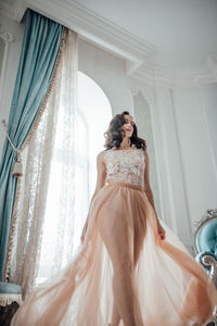 Young woman wearing dress standing in corridor of building