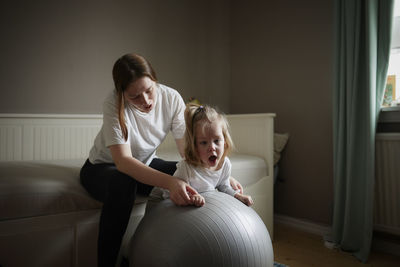 Mother exercising with disabled child at home