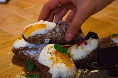 Cropped hand holding dessert at table