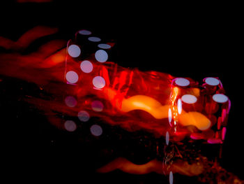 Close-up of illuminated lighting equipment against black background