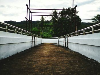 Empty footbridge against sky