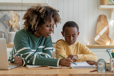 Portrait of smiling boy reading book at home