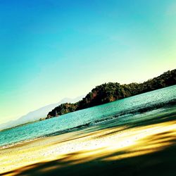 Scenic view of beach against clear blue sky
