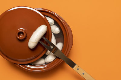 High angle view of electric lamp against orange background