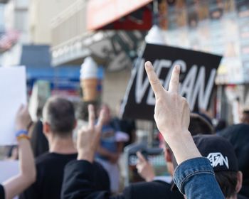 People gesturing while protesting in front of building