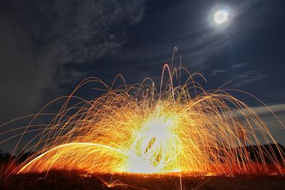 Low angle view of fireworks against sky at night