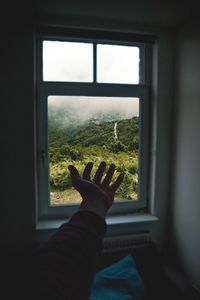 Silhouette man looking through window