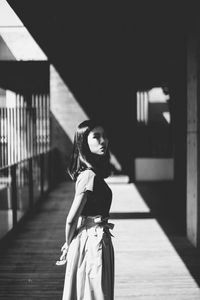 Portrait of young woman standing on hardwood floor