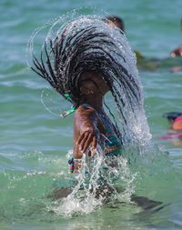 Side view of woman tossing wet hair in sea