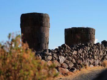 Low angle view of rocks against clear blue sky