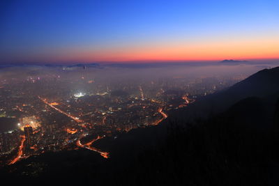 Aerial view of illuminated cityscape against sky at night