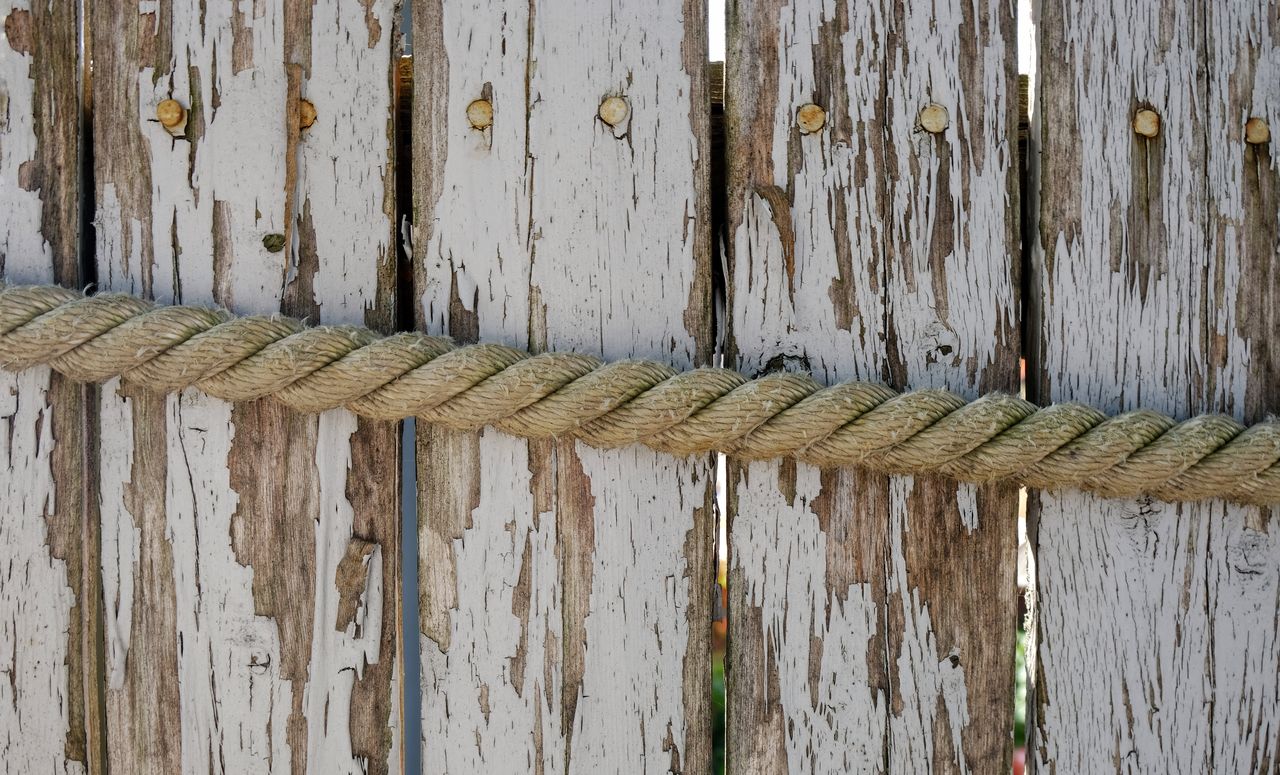 wood - material, rope, textured, no people, close-up, full frame, strength, day, pattern, backgrounds, outdoors, tied up, old, plank, metal, weathered, boundary, safety, wall - building feature, rough, wooden post