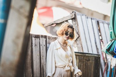 Portrait of young woman wearing sunglasses standing outdoors