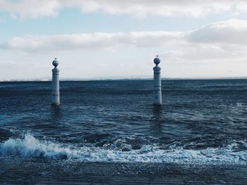 Man standing on lighthouse by sea against sky