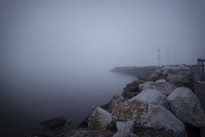 Rocks by sea against sky