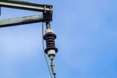 Low angle view of electric lamp against blue sky