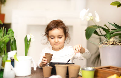 Portrait of cute girl using mobile phone at home