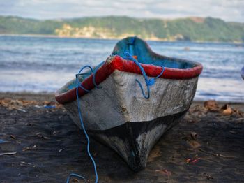 Close-up of red umbrella on beach