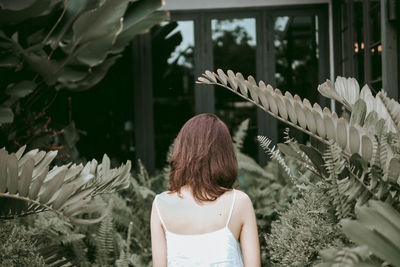 Rear view of woman standing by plants