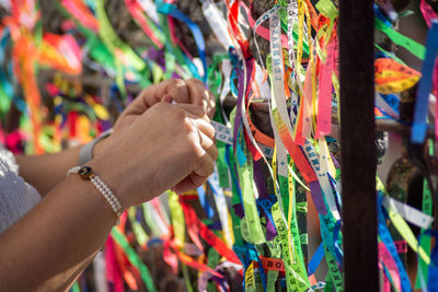 Cropped hand of woman holding colorful clothes