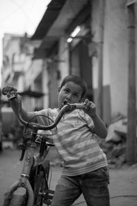 Full length portrait of girl standing by bicycle in city