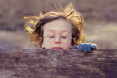 Close-up of cute boy wearing eyeglasses on wood