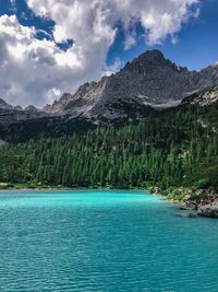 Scenic view of lake by mountains against sky