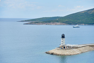 Lighthouse by sea against sky