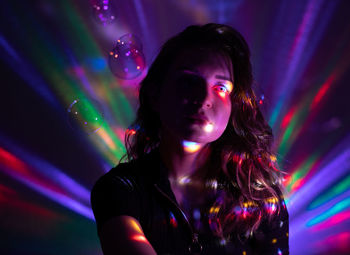 Portrait of woman in illuminated nightclub