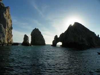 Arch of cabo san lucas and rock formation in sea against sky