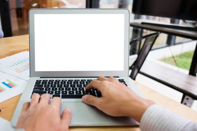 Midsection of man using laptop on table