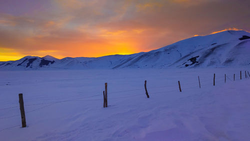 Scenic view of snow covered mountains against sky during sunset