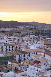 High angle view of houses in city during sunset