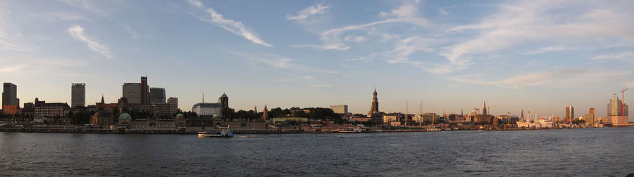View of buildings at waterfront against cloudy sky
