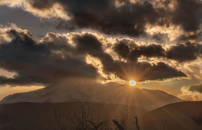 Scenic view of snowcapped mountains against sky during sunset